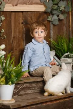 Surprised child playing with Easter bunny in a green grass Foto stock