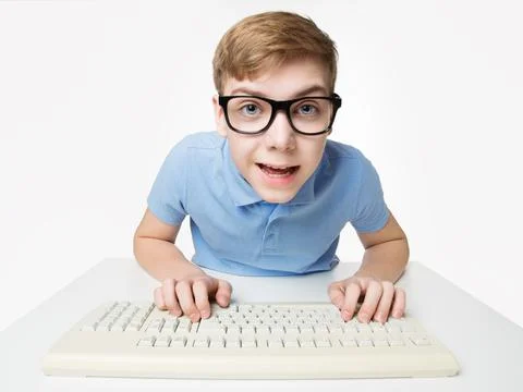 Surprised Child using Computer Keyboard. Teenage Boy Hacker typing on Laptop Stock Photos