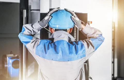 Surprised CNC Machine Operator Wearing Blue Hard Hat and Safety Gloves. Stock Photos