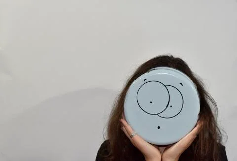 Surprised emoji painted on the bottom of the kitchenware Stock Photos