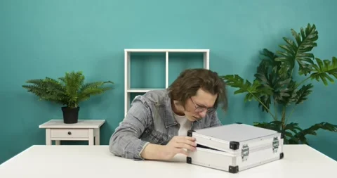 Surprised excited young man opening a suitcase opening her mouth in amazement, Stock Footage 158947042