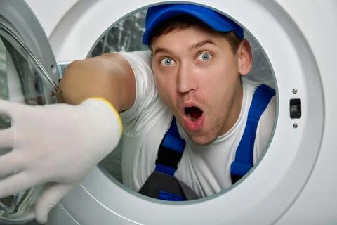 Surprised face professional locksmith engaged in repair of household appliances Stock Photos