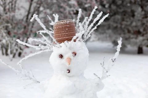 Surprised face of snow man made with hands outside with cone eyes, carrot nose Stock Photos