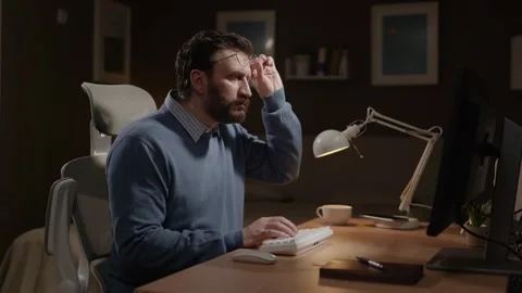 Surprised freelancer stares at his computer screen, his expression one of shock Stock Footage 337645234