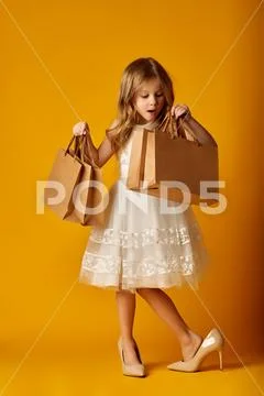 Surprised girl in big high heels with packets Stock Photos