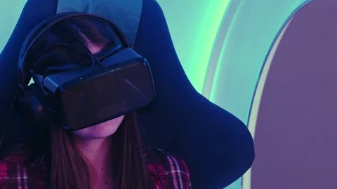 Surprised girl experiencing virtual reality in a moving interactive chair Stock-Footage 74388732