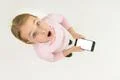 The surprised girl stand with a smartphone. View from above Photo