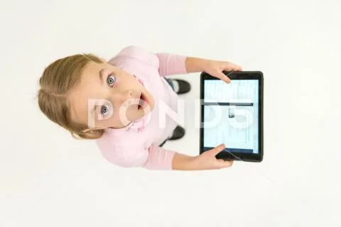 The surprised girl stand with a tablet. View from above Stock Photos