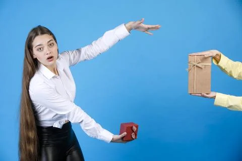 Surprised girl with tiny box displaying invisible size, while crop male hand Stock Photos