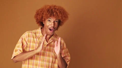 Surprised guy looking to the side to show mockup space , isolated on brown Stock Footage 254914299