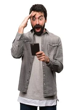 Surprised Handsome man with beard talking to mobile on white background Photos