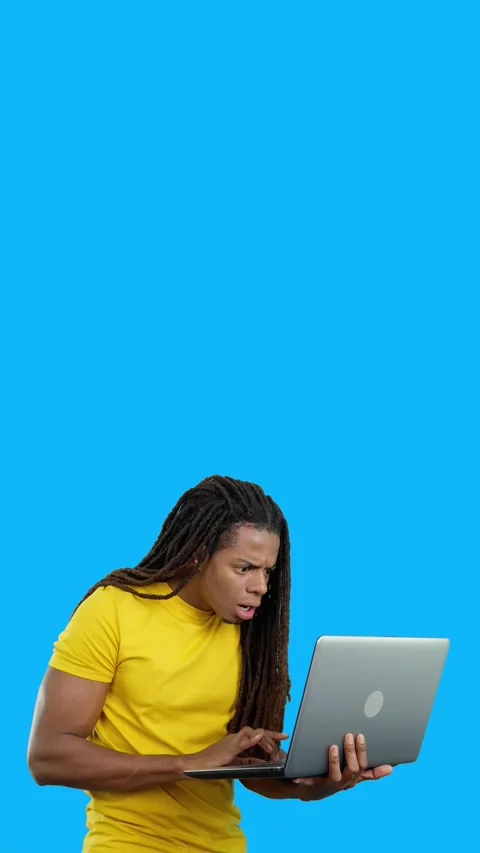 Surprised latin man with dreadlocks using a laptop Vídeos de archivo 252484277