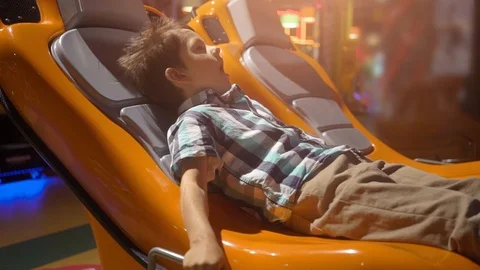 Surprised little boy in a moving interactive chair Stock Footage 111666252