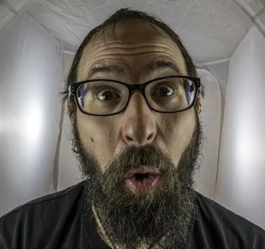 A surprised looking bearded man with glasses Stock Photos