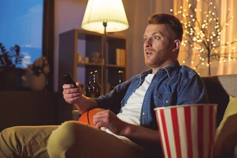 Surprised male keeping remote controller Foto stock