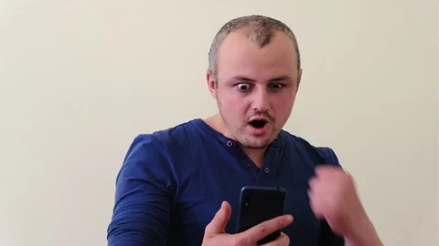 A surprised man be rejoice read mobil phone message happy rejoicing Stock Footage 152732695