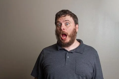 Surprised Man With Beard Expressing Shock Against Plain Background Stock Photos