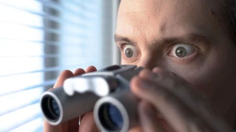 Surprised man with binoculars. Curious guy with big eyes. Stock Footage 123700966