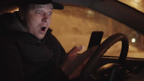 Surprised man in the car looking at the phone Stock Footage 147667258