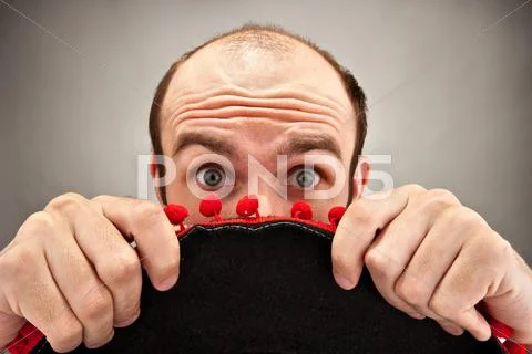 Surprised man hiding behind sombrero hat Stock Photos