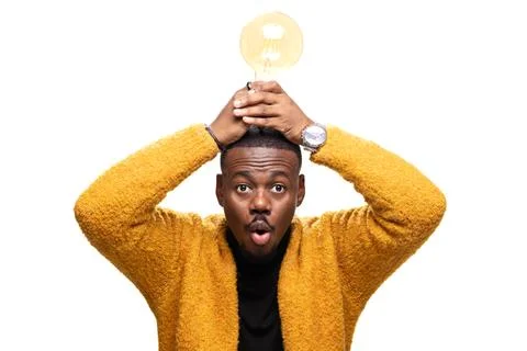 Surprised man holds glowing light bulb symbolizing a bright idea or innovative Stock Photos