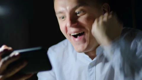 Surprised man looking at smartphone screen and rejoices Stock Footage 142882807