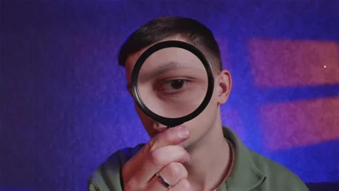 Surprised man looking through magnifying glass and saying wow Stock Footage 333757112
