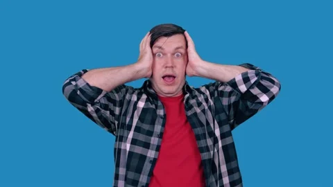 A surprised man screams while holding his head with both hands. Stock Footage 147535596
