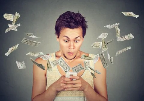 Surprised man using smartphone dollar bills flying away from screen Stock Photos