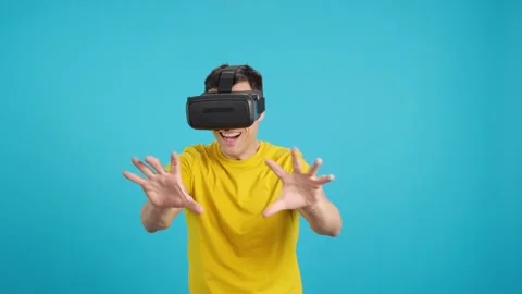 Surprised man using Virtual reality goggles looking around Stock Footage 244086308