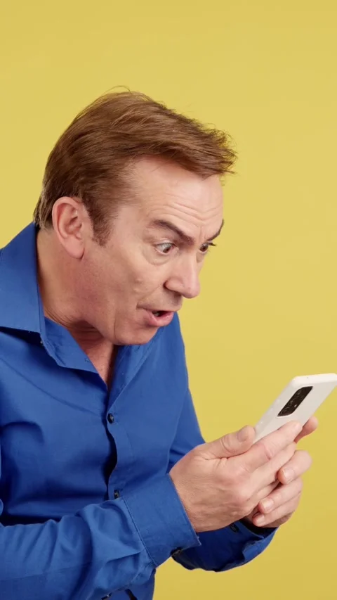 Surprised mature man looking at the mobile phone Stock Footage 242329607