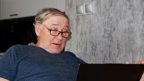 Surprised middle aged man looking at laptop screen indoors Stock Photos