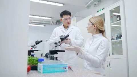 Surprised multiethnic scientists team looking at microscope and extremely happy  Stock Footage 233309682