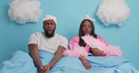 Surprised plump ethnic dark skinned woman and man watch something terrifying Stock Footage 148995070