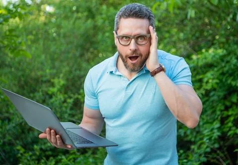 Surprised programmer man working online on laptop. photo of programmer man Stock Photos