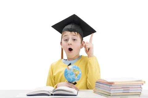 Surprised schoolboy in student hat raised index finger up. Concept idea or in Stockfoto's