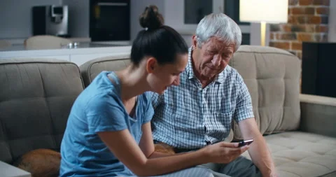 Surprised senior bearded father while sitting on the gray sofa in the light Stock Footage 135980449