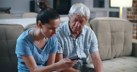 Surprised senior bearded father while sitting on the gray sofa in the light Stock Footage 135980600