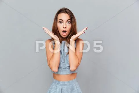 Surprised shocked young woman standing with opened mouth Stock Photos