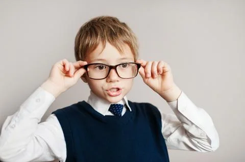 Surprised smart boy in big glasses staring at the camera. Education. Objects Stock Photos