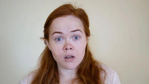 Surprised. Startled and impressed, charmed by pretty red-haired millennial girl Stock Footage 128455772