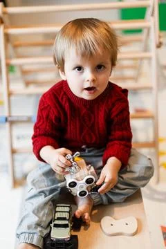 Surprised Toddler Boy Looking at Camera While Playing with Activity Cube an.. Fotos Stock
