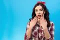 The surprised woman gesturing on the blue background Photo