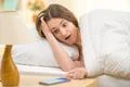 The surprised woman with a phone on the bed Photo