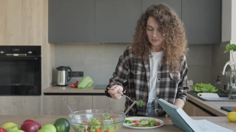 Surprised Woman Reading Unexpected Recipe In Cookbook While Standing In Kitchen Stock Footage 311271353
