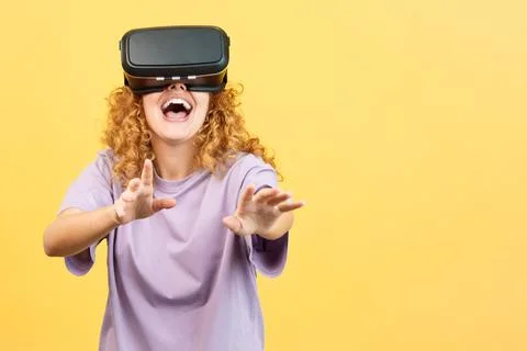 Surprised woman smiling while using virtual reality goggles 스톡 사진