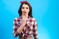 The surprised woman standing on the blue background Photo