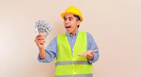 Surprised young Asian construction worker wearing safety vest and hard hat .. Stock Photos