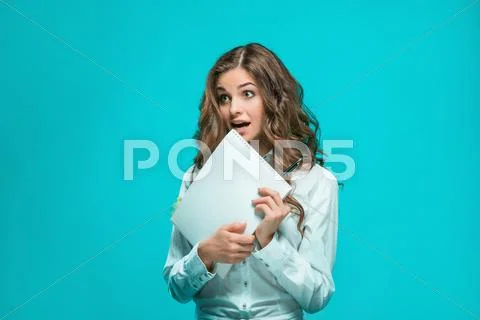 Surprised young business woman with pen and tablet for notes on blue background Stock Photos