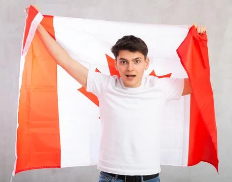 Surprised young guy holding Canada flag Stock Photos